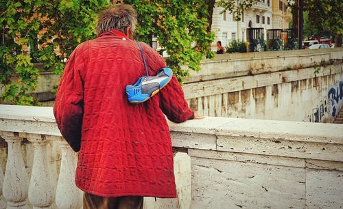 Rear view of woman standing against red wall