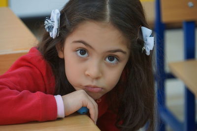 Close-up portrait of girl at table