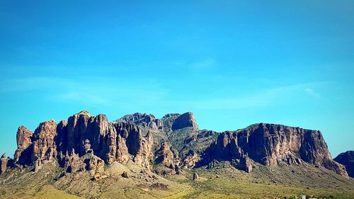 Low angle view of landscape against blue sky