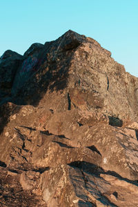 Low angle view of rocky mountain against sky