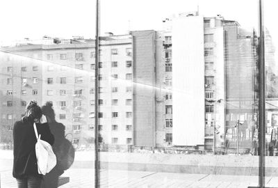 Rear view of woman by window