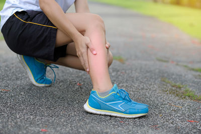 Low section of woman suffering from pain on road