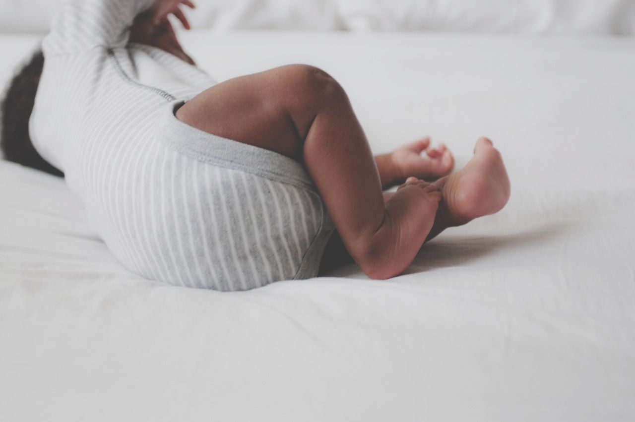 indoors, bed, lifestyles, relaxation, low section, person, baby, barefoot, unknown gender, leisure activity, childhood, home interior, babyhood, lying down, bedroom