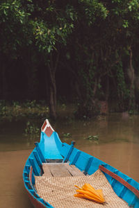 Boat moored in lake against trees