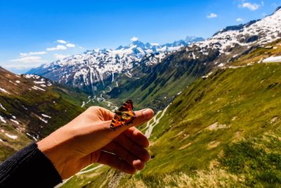 Midsection of woman holding ice cream against mountains