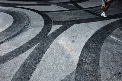 Low section of woman walking on patterned ground