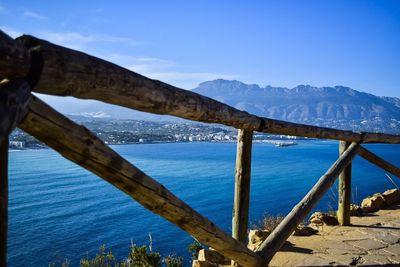 Scenic view of sea and mountains against blue sky