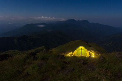 Scenic view of illuminated mountains against sky at night