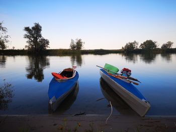 Boat moored on lake against sky