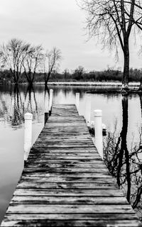 Wooden pier on lake against sky