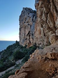 Rock formation on beach against sky