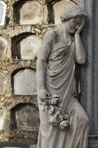 Close-up of buddha statue in cemetery