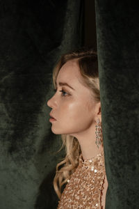 Fashionable young woman by curtain at new year's party