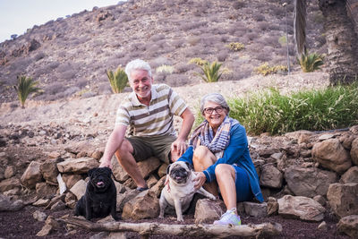 Senior couple with dogs on rocks