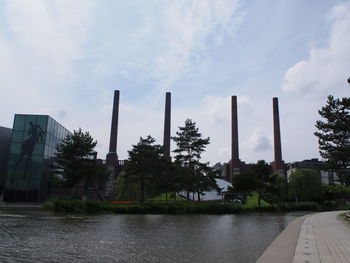 Plants growing by lake against sky