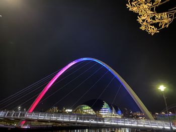 Low angle view of illuminated bridge against sky at night