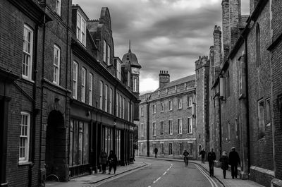 People walking on road amidst buildings in city