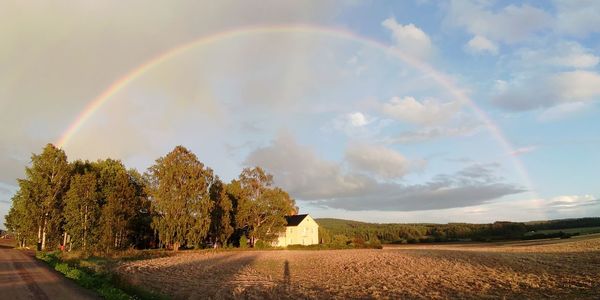 Scenic view of rainbow over land against sky
