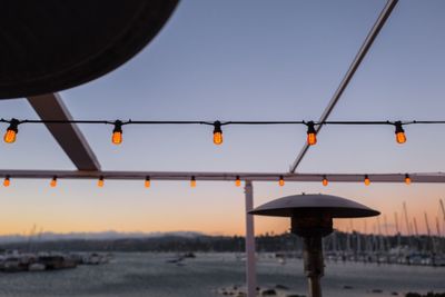 Close-up of water hanging against sky during sunset