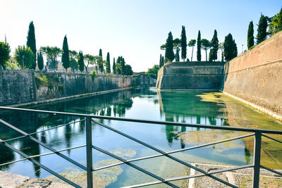 Panoramic view of swimming pool by building against sky