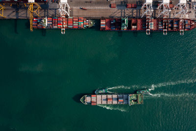 Aerial top view of containers ship floating in sea at shipping port for international import export 