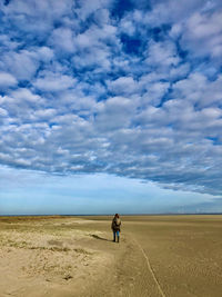 Rear view of man on land against sky