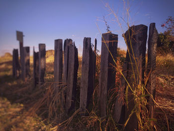 Panoramic shot of wooden post on field against sky