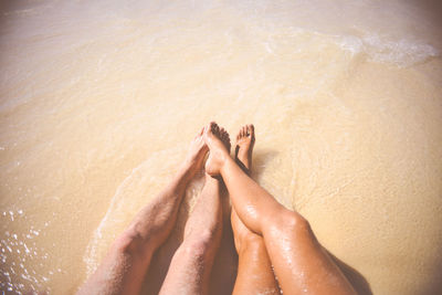 Low section of woman relaxing on beach