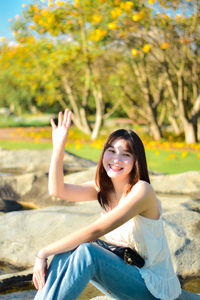 Portrait of young woman sitting on chair at beach