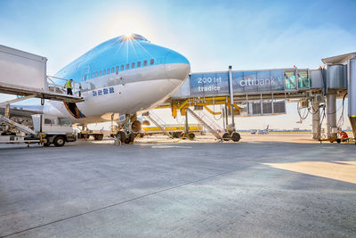 Airplane on airport runway against sky