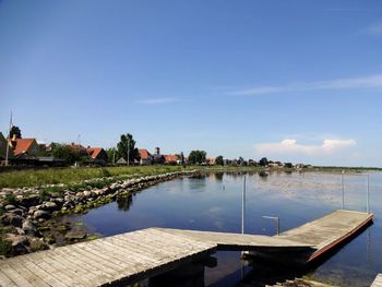 View of swimming pool by lake against sky