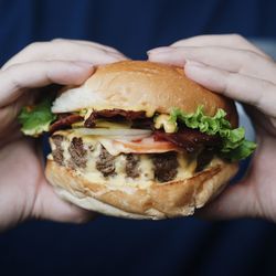 Cropped image of hands holding burger 