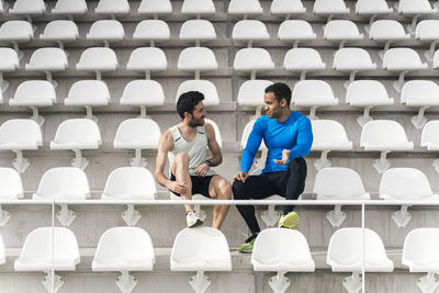 Full length athletes sitting on chair at stadium