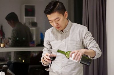 Full length of young man drinking glass