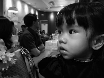 Close-up of girl looking away while sitting on restaurant