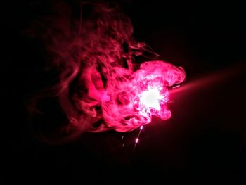 Close-up of illuminated red water against black background