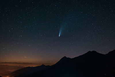 Scenic view of silhouette mountains against sky at night