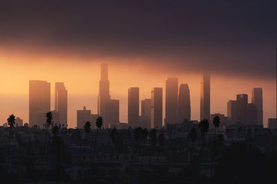 Low angle view of buildings in city against sky during sunset