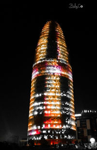 Low angle view of illuminated buildings against sky at night