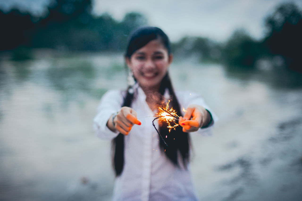 PORTRAIT OF WOMAN WITH FIRE HYDRANT AT NIGHT