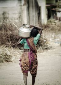 Full length rear view of woman walking on field