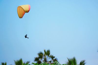 Low angle view of kite flying against clear blue sky