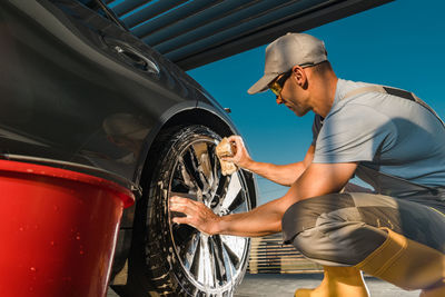 Side view of man repairing car