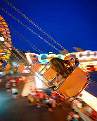 Girl enjoying chain swing ride at night