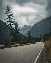 Road by mountains against sky