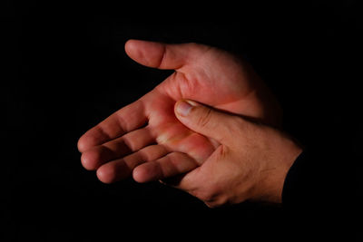 Close-up of hands against black background