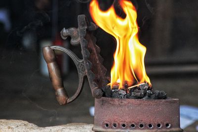 Close-up of burning candles and charcoal iron