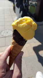 Cropped hand holding ice cream cone