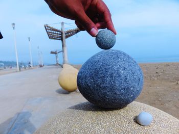 Human hand holding ball on beach