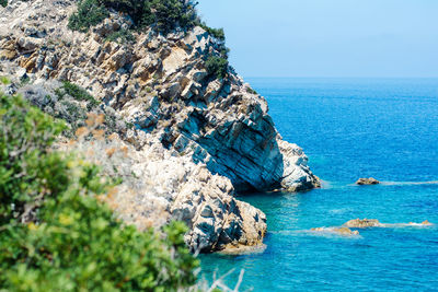 Rock formation in sea against sky